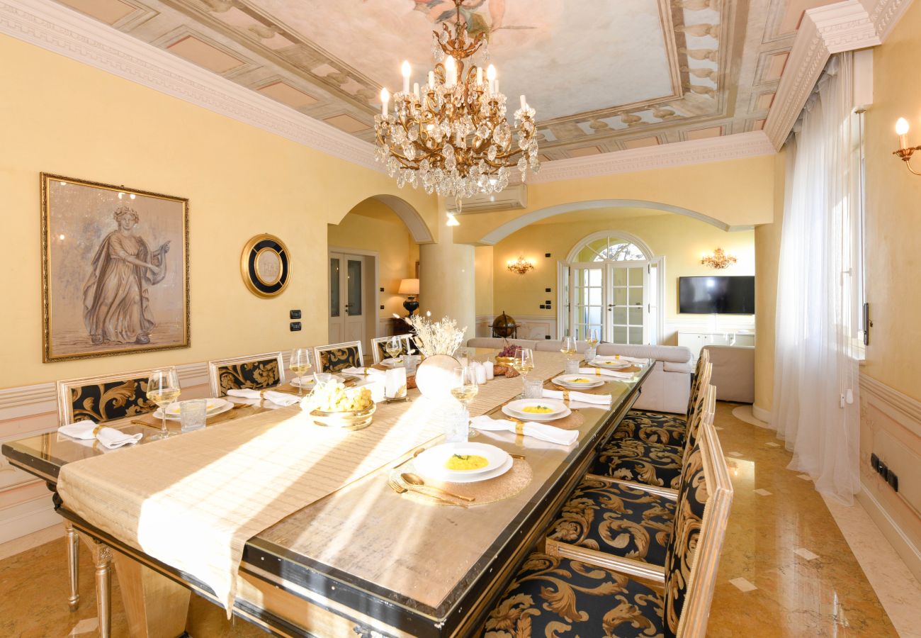 Sala da pranzo elegante con tavolo imperiale,sedie ricamate e affreschi a Desenzano Villa Bugatti