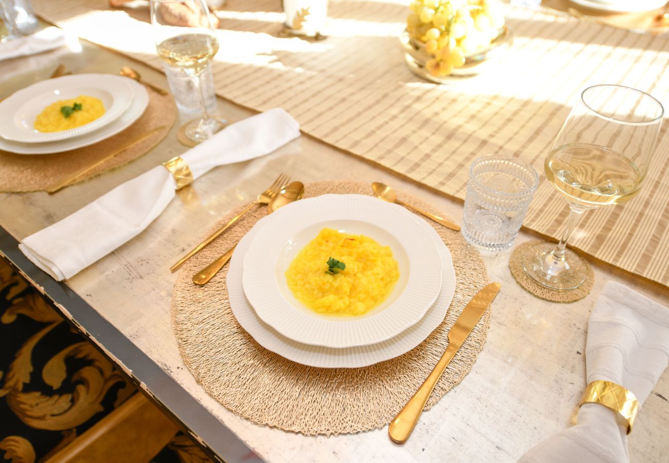 Tavola imbandita con calici di vino e posate dorate a Villa Bugatti