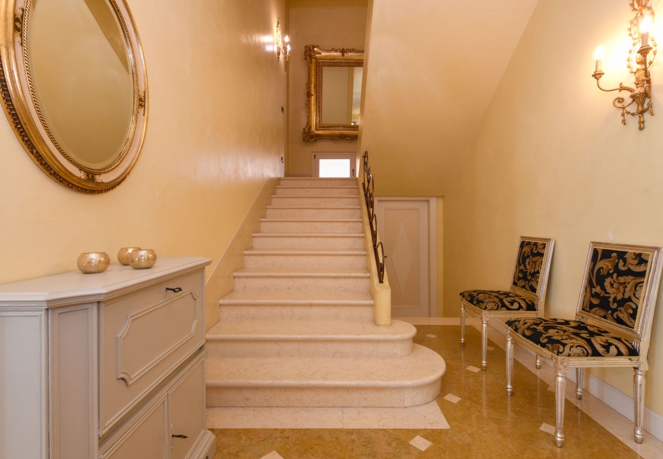 Ingresso elegante di Villa Bugatti con scala in marmo e specchi dorati