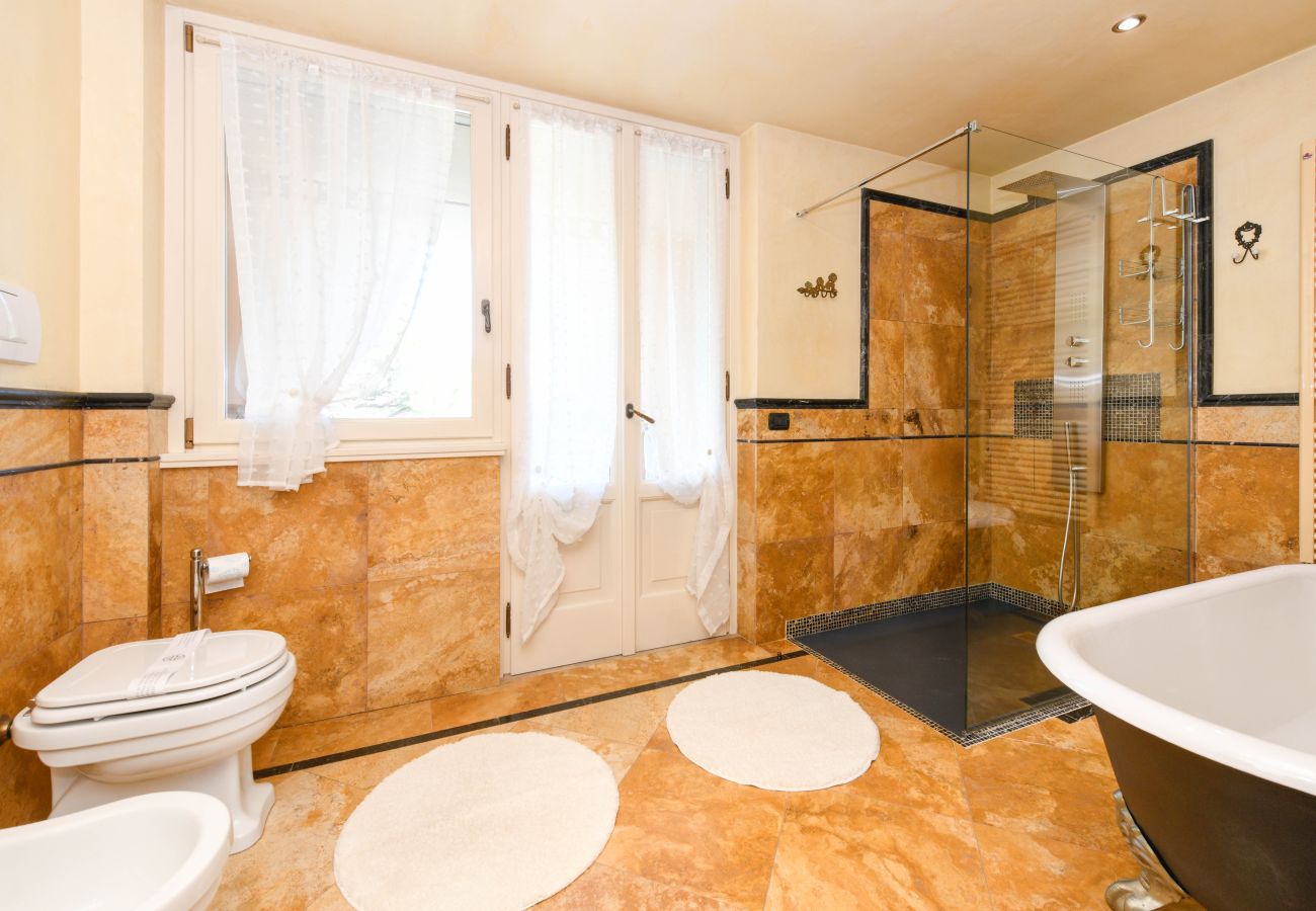 Bagno padronale con doccia walk-in, marmo e finestra Villa Bugatti