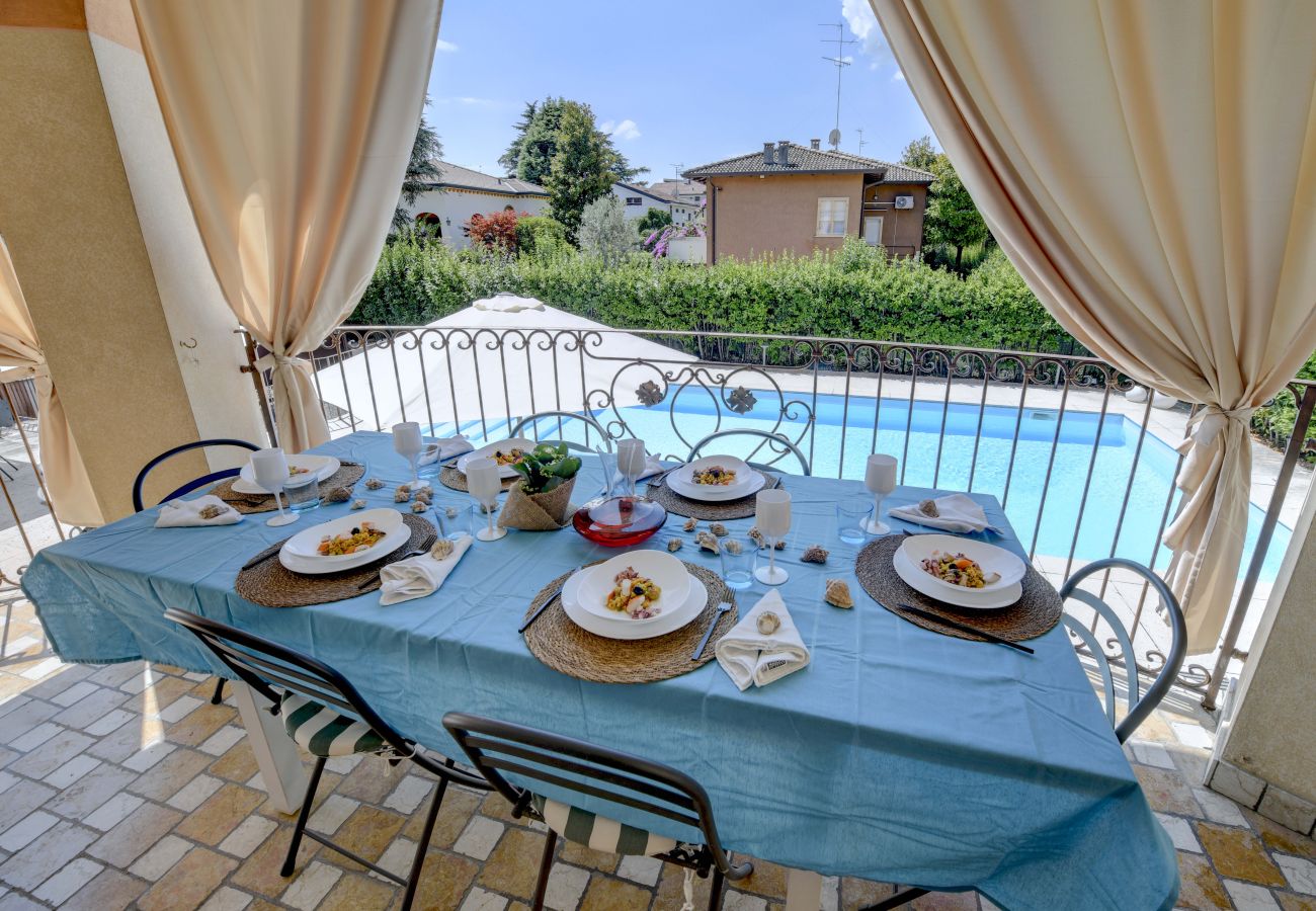 Gedeckter Tisch auf Terrasse mit Pool in Villa Bugatti