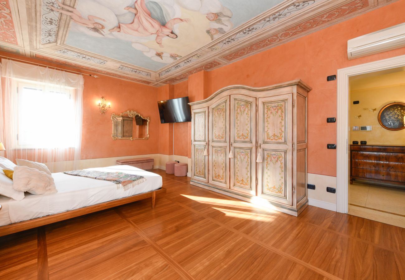 Helles Schlafzimmer mit Fresko, dekorativem Schrank und Wohnbereich Villa Bugatti