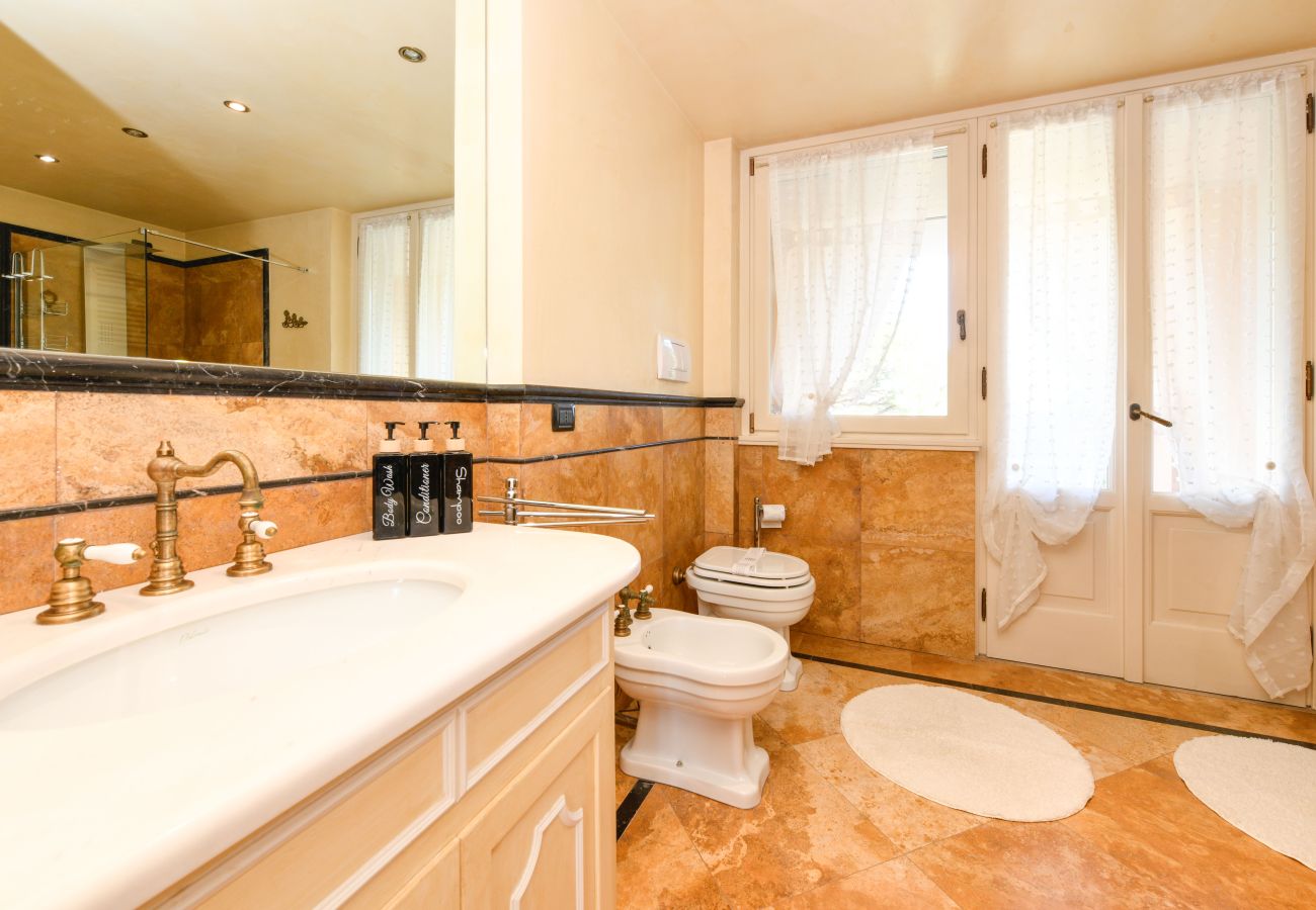 Bright master bathroom with marble and window Villa Bugatti