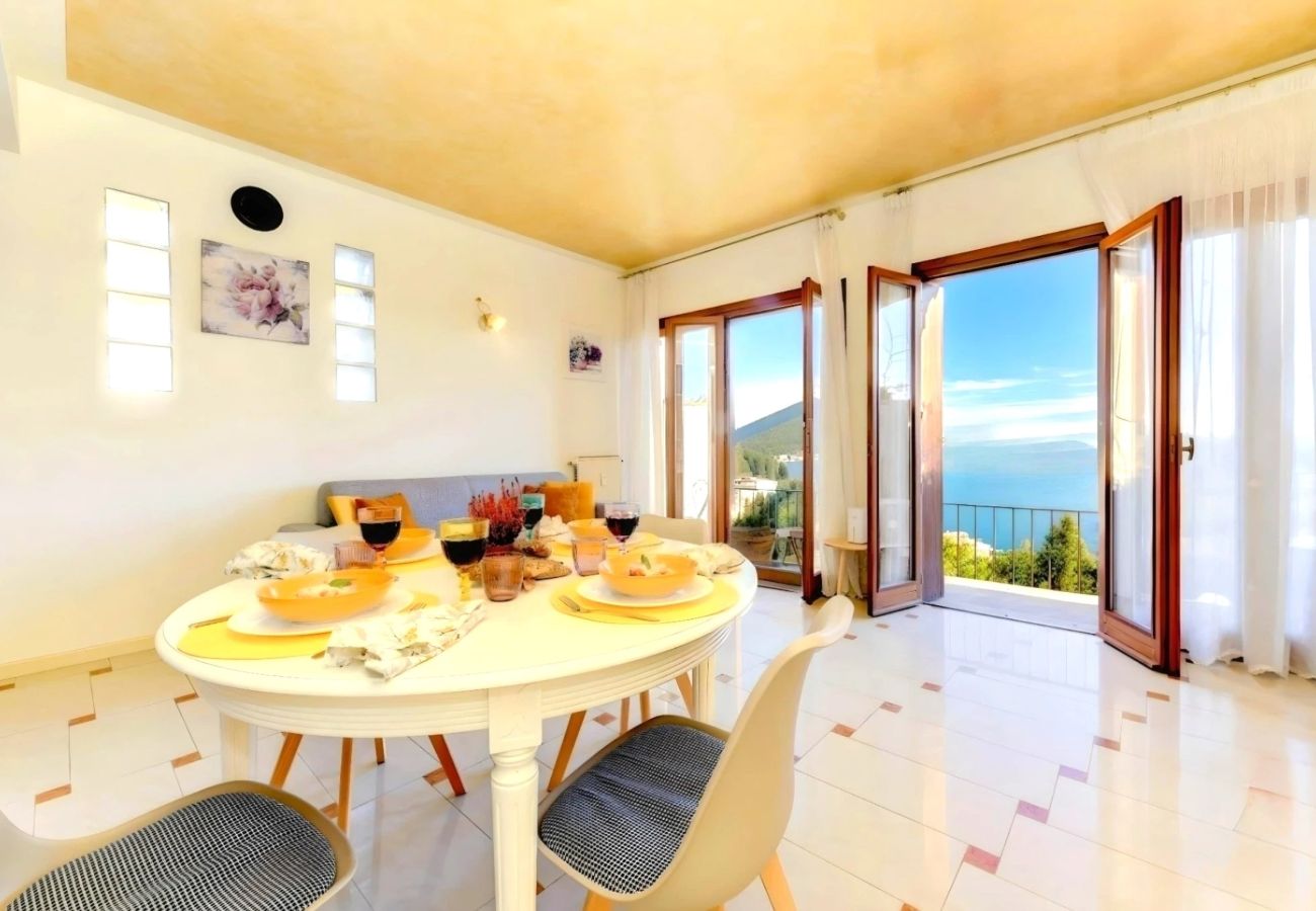 Jasny salon z stołem jadalnym i balkonem nad jeziorem