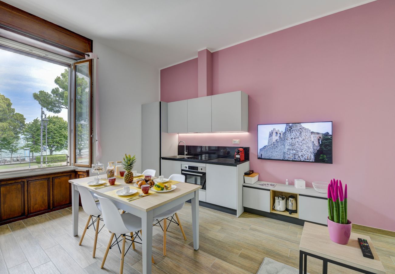 Nowoczesny salon z różową ścianą i kuchnią