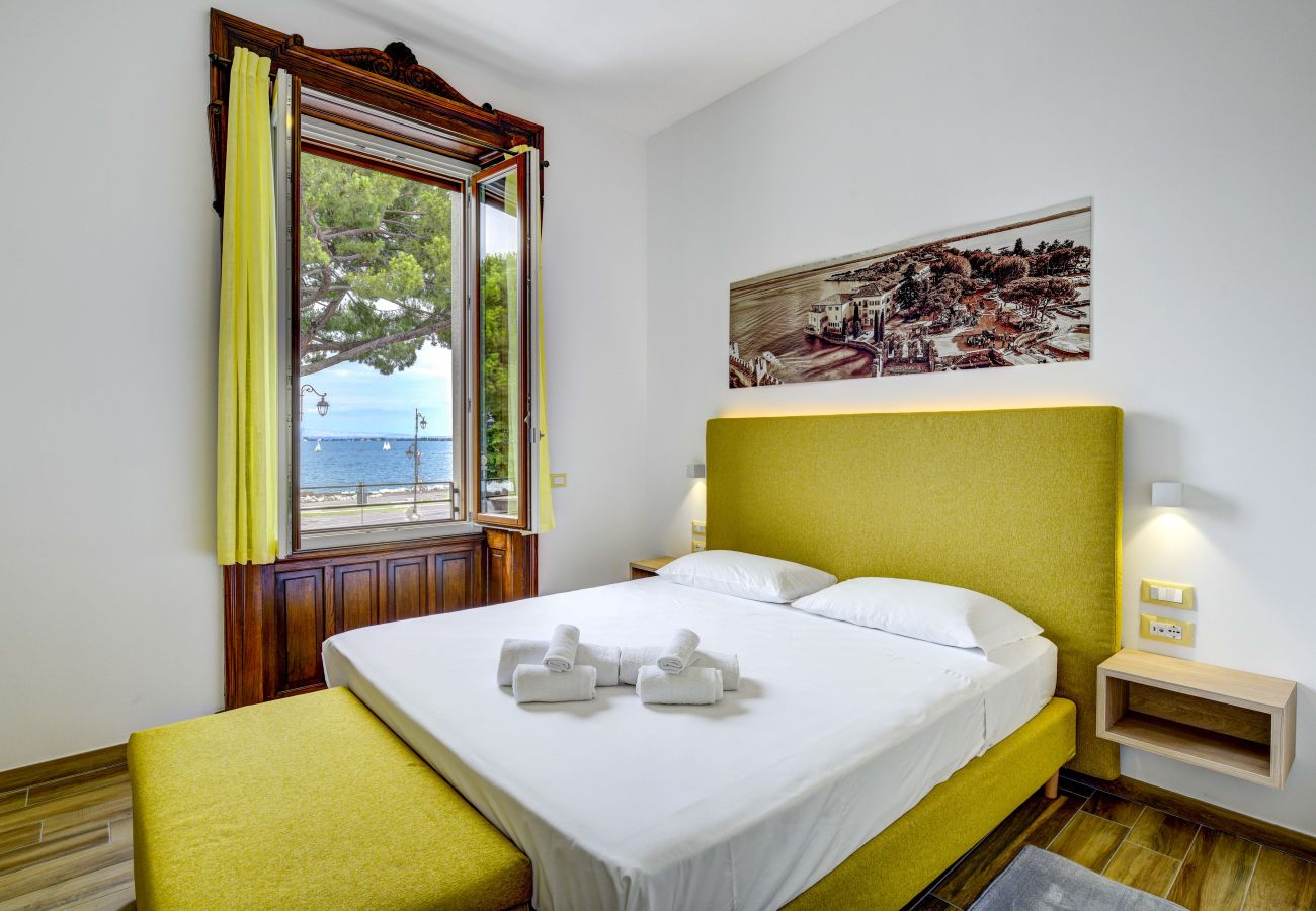 Sypialnia z dużym oknem i widokiem na jezioro Garda