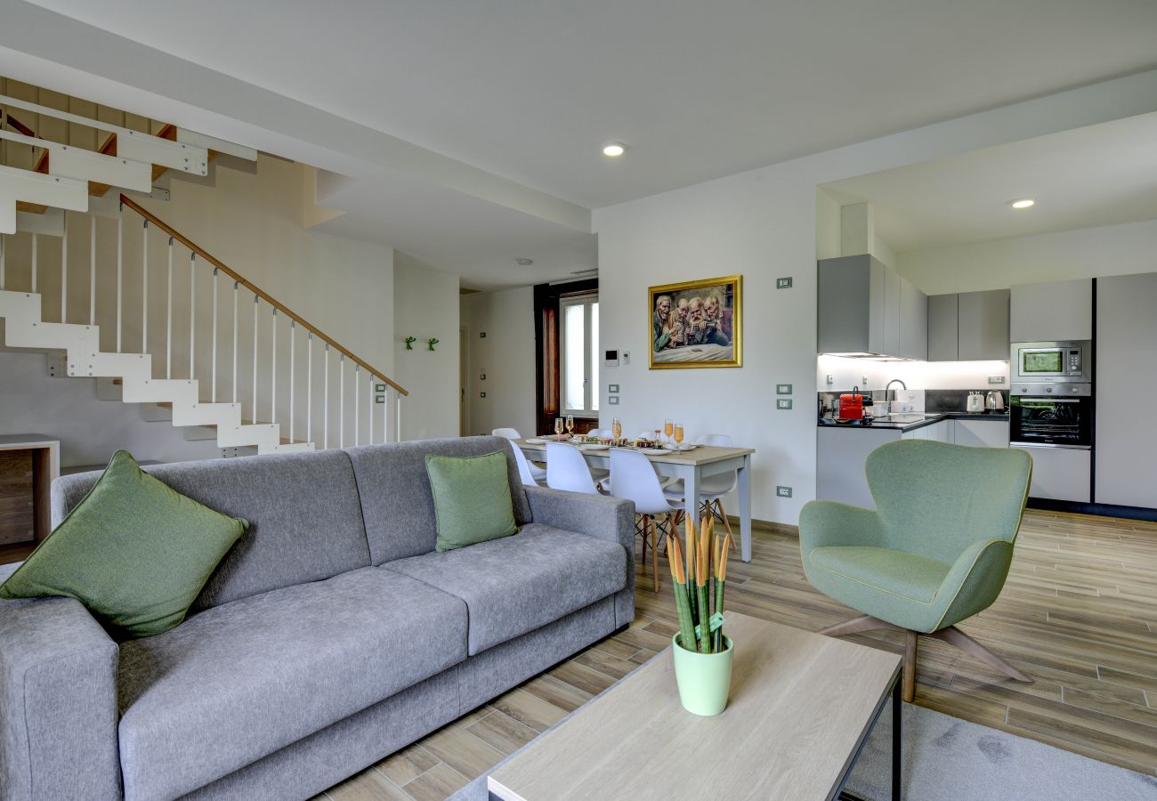 Nowoczesny salon z szarą sofą i schodami